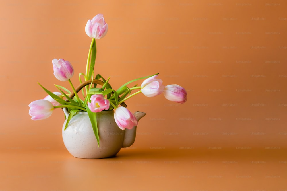 un vase rempli de fleurs roses sur une table