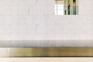 uma parede de mármore branco com um espelho acima dela