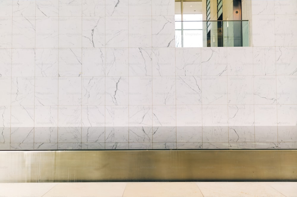a white marble wall with a mirror above it