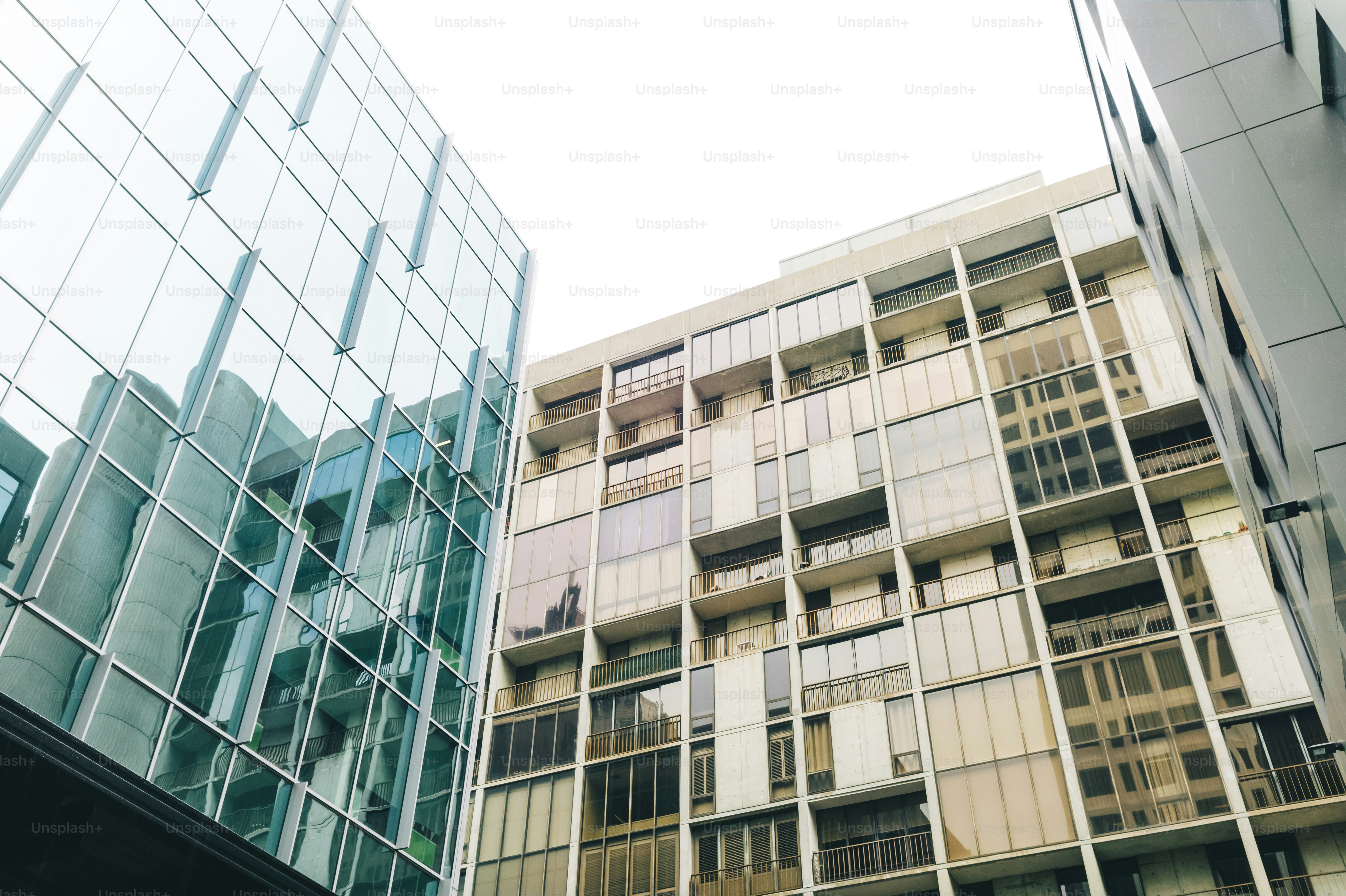 A tall building with lots of windows next to other buildings photo ...