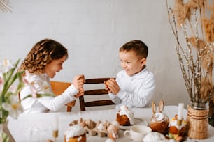 a young boy and a young girl sitting at a table