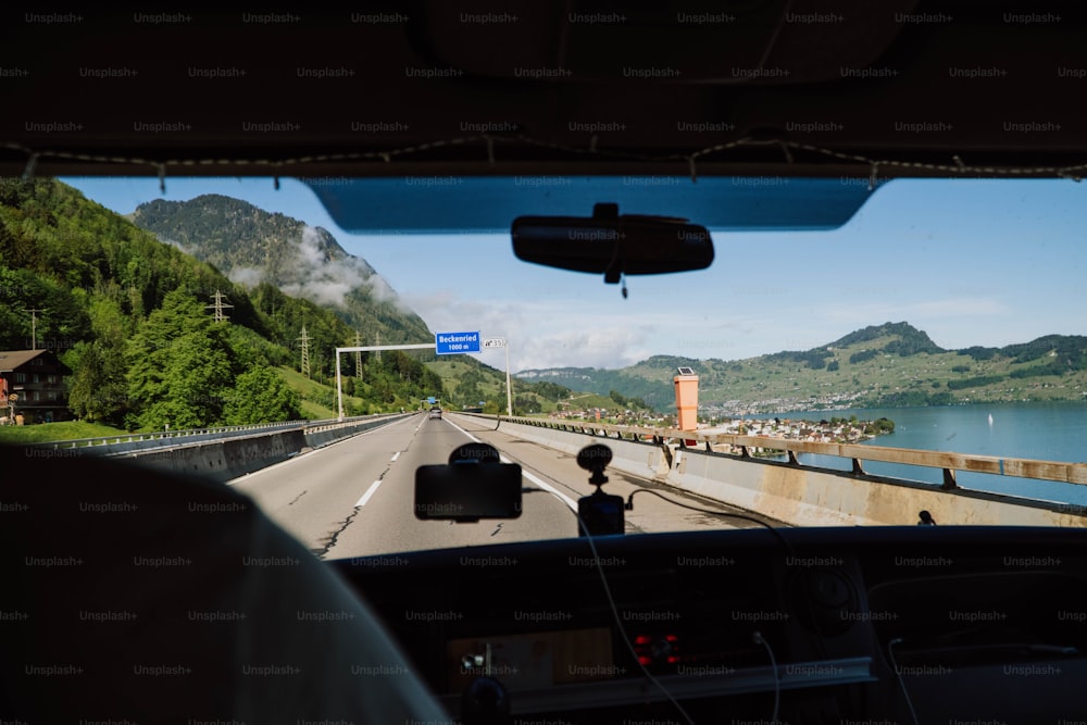 a view from inside a car of a road and a body of water