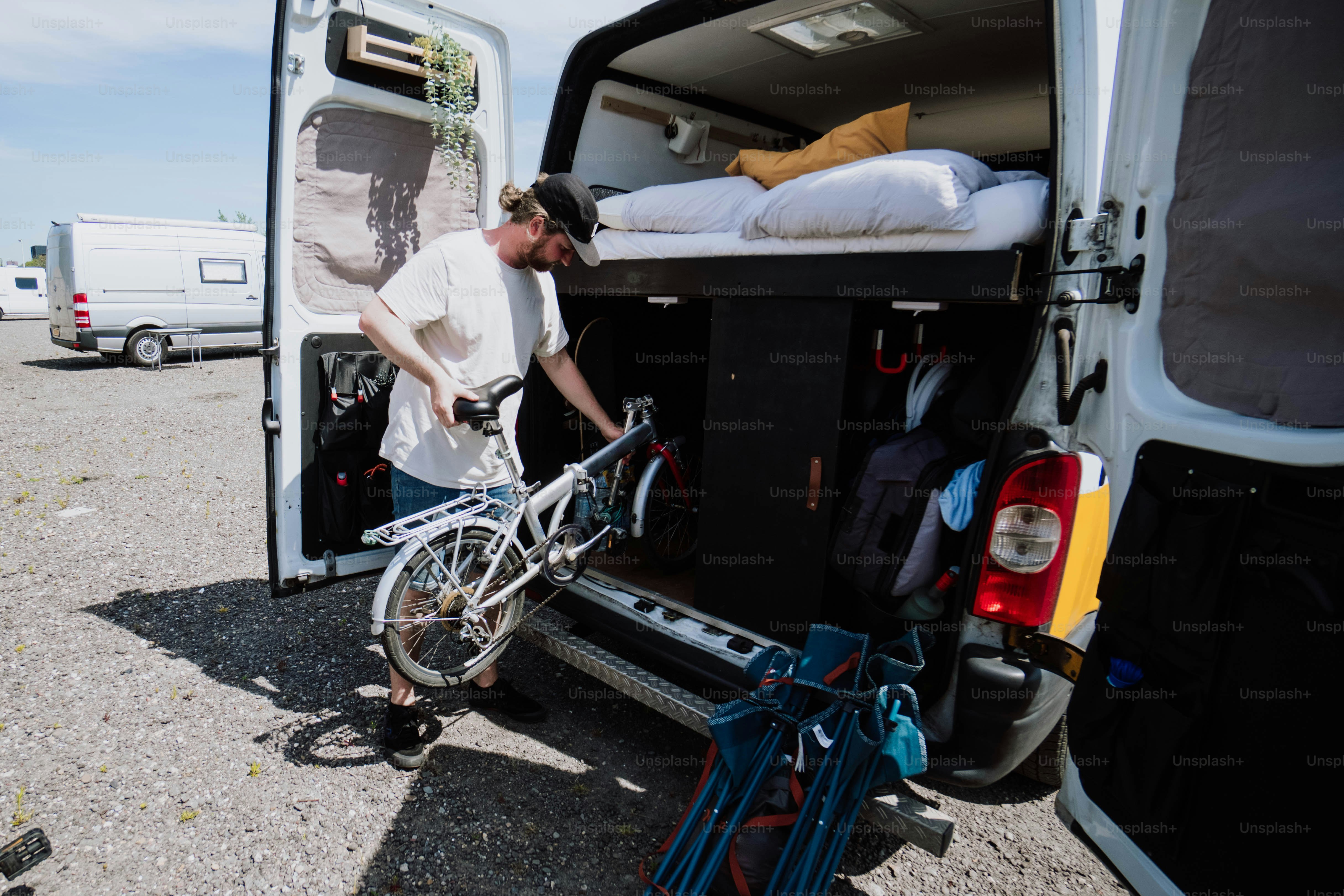 a man loading his bike into the back of a van