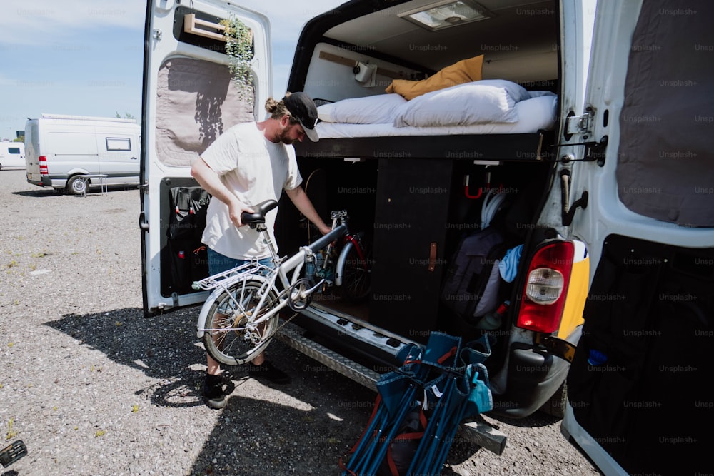 a man loading his bike into the back of a van