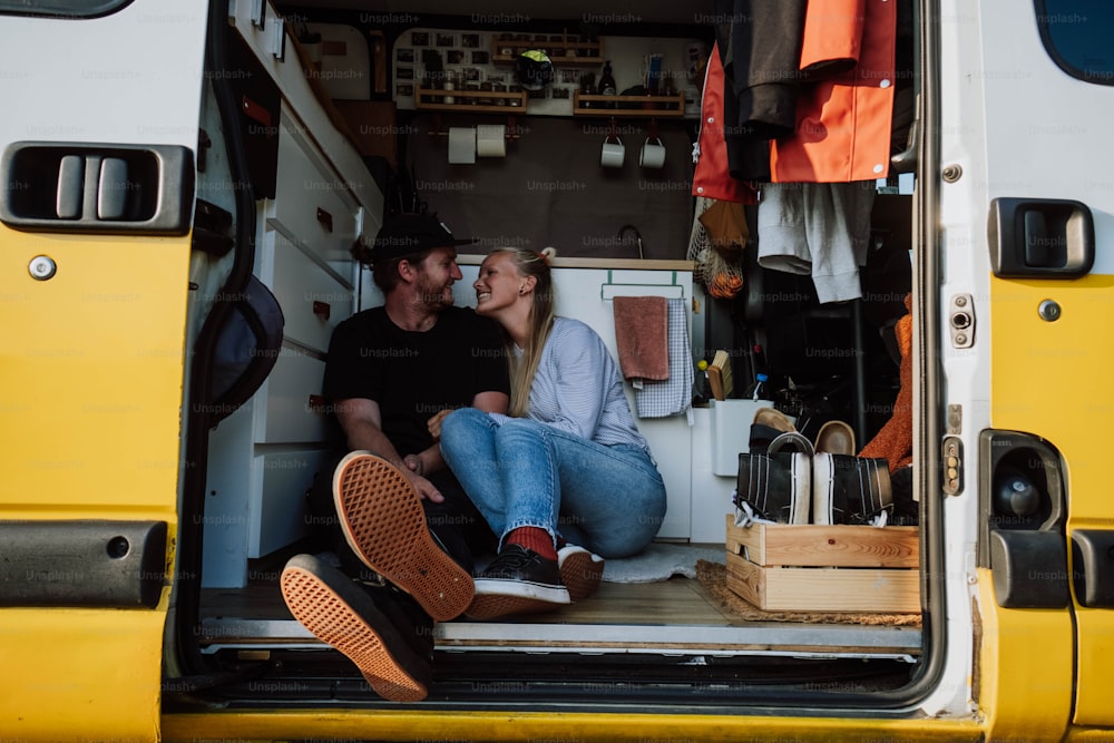 a man and a woman sitting in the back of a van