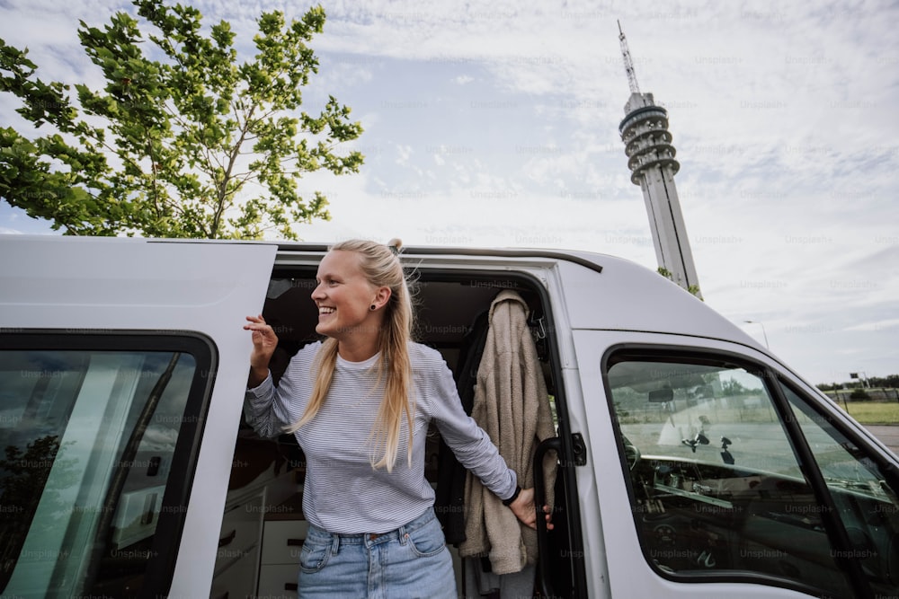 a woman standing in the back of a white van