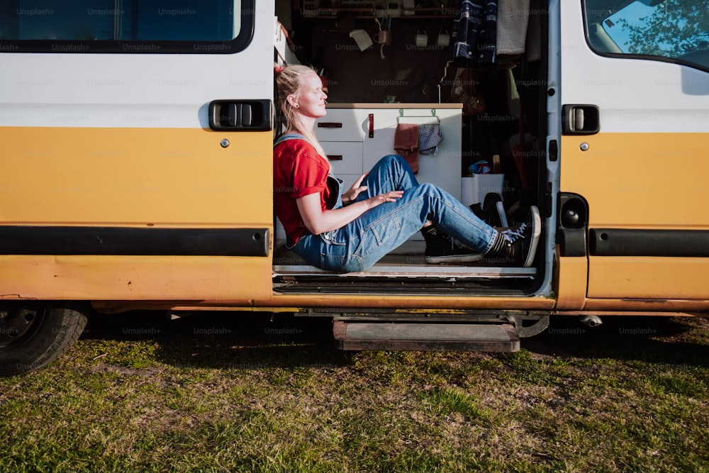 um homem sentado na parte de trás de uma van amarela