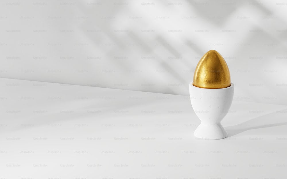 a white vase with a gold egg inside of it
