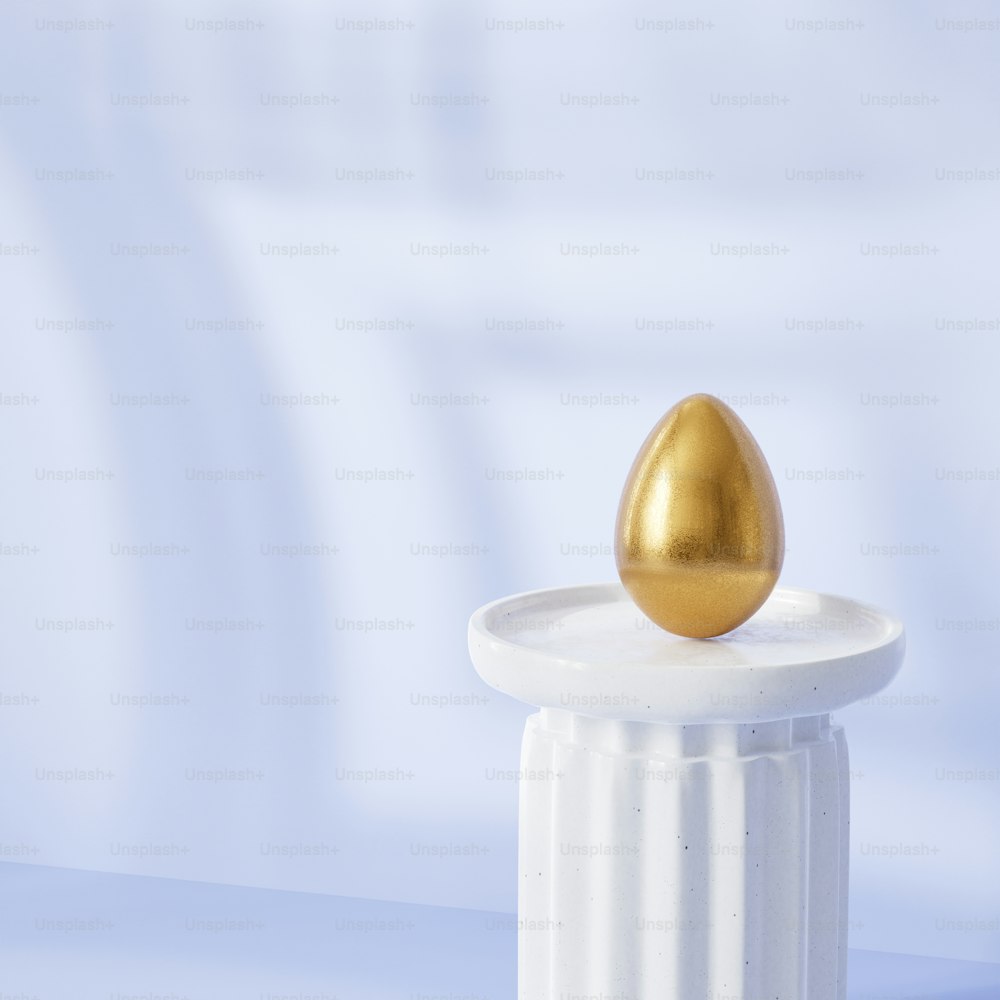 a golden egg sitting on top of a white pedestal