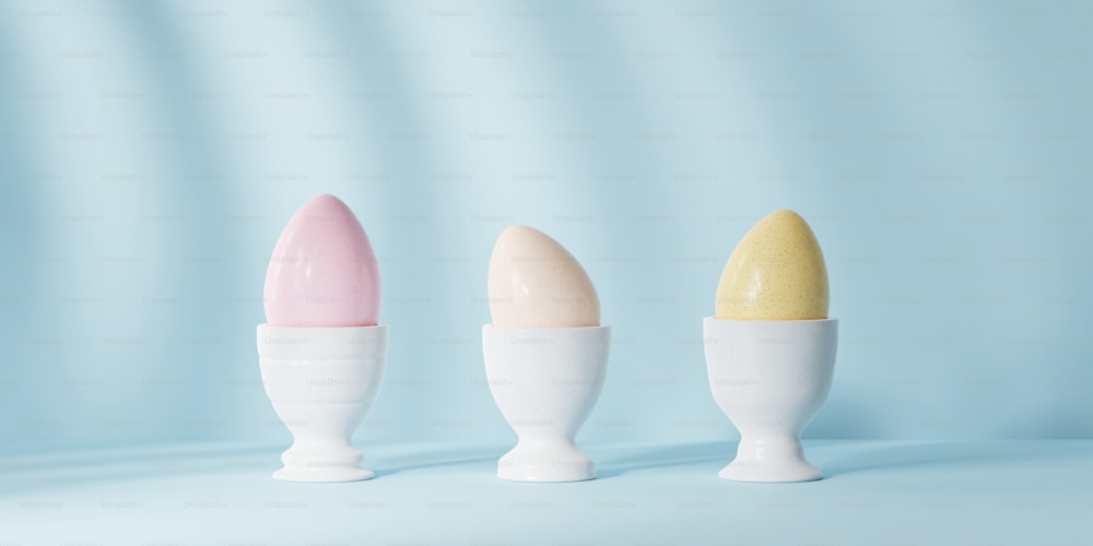Tre gusci d'uovo in fila su sfondo blu