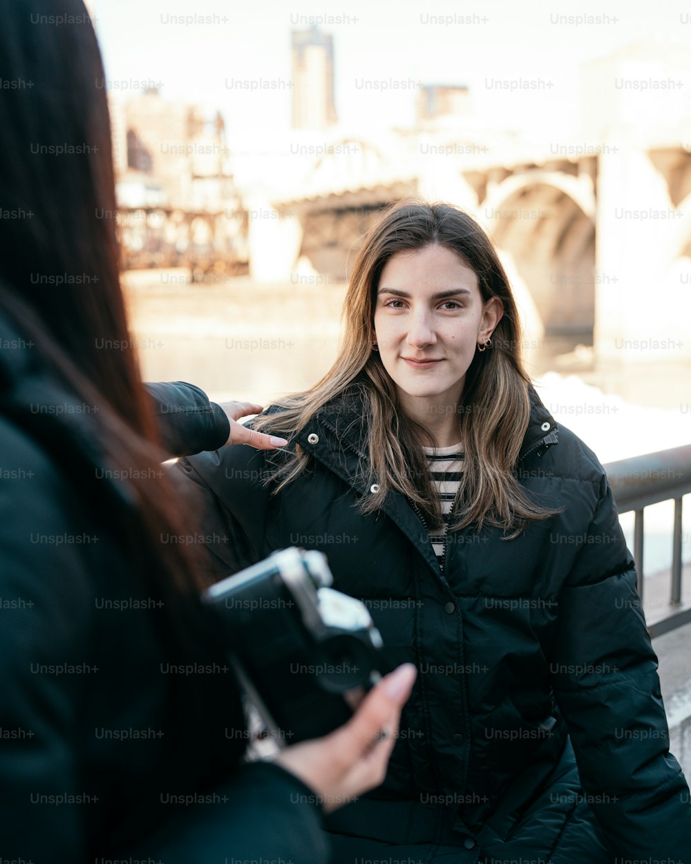 uma mulher de pé ao lado de uma mulher segurando uma câmera