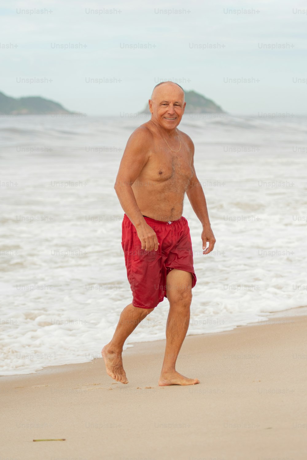 Ein Mann geht an einem Strand am Meer spazieren
