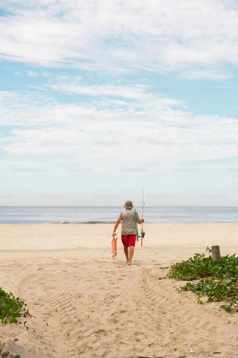 uma pessoa andando em uma praia com uma prancha de surf