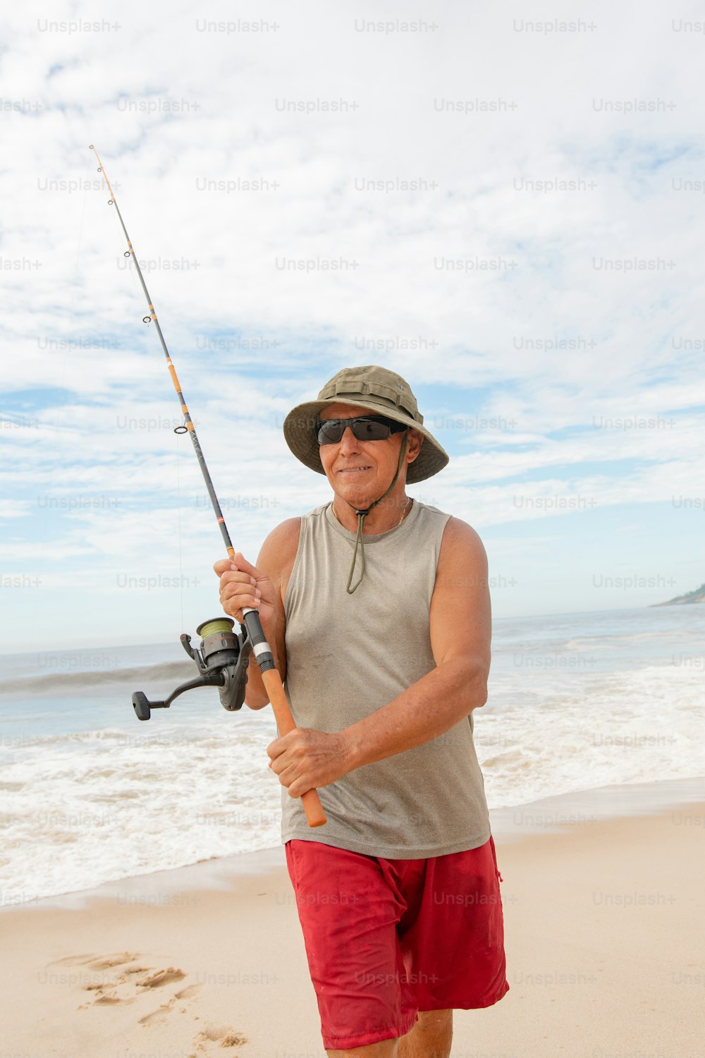 a man holding a fishing rod on the beach
