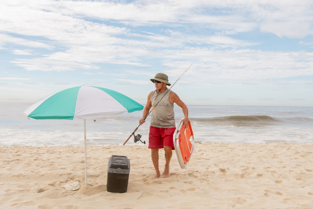 a man standing on a beach holding a surfboard
