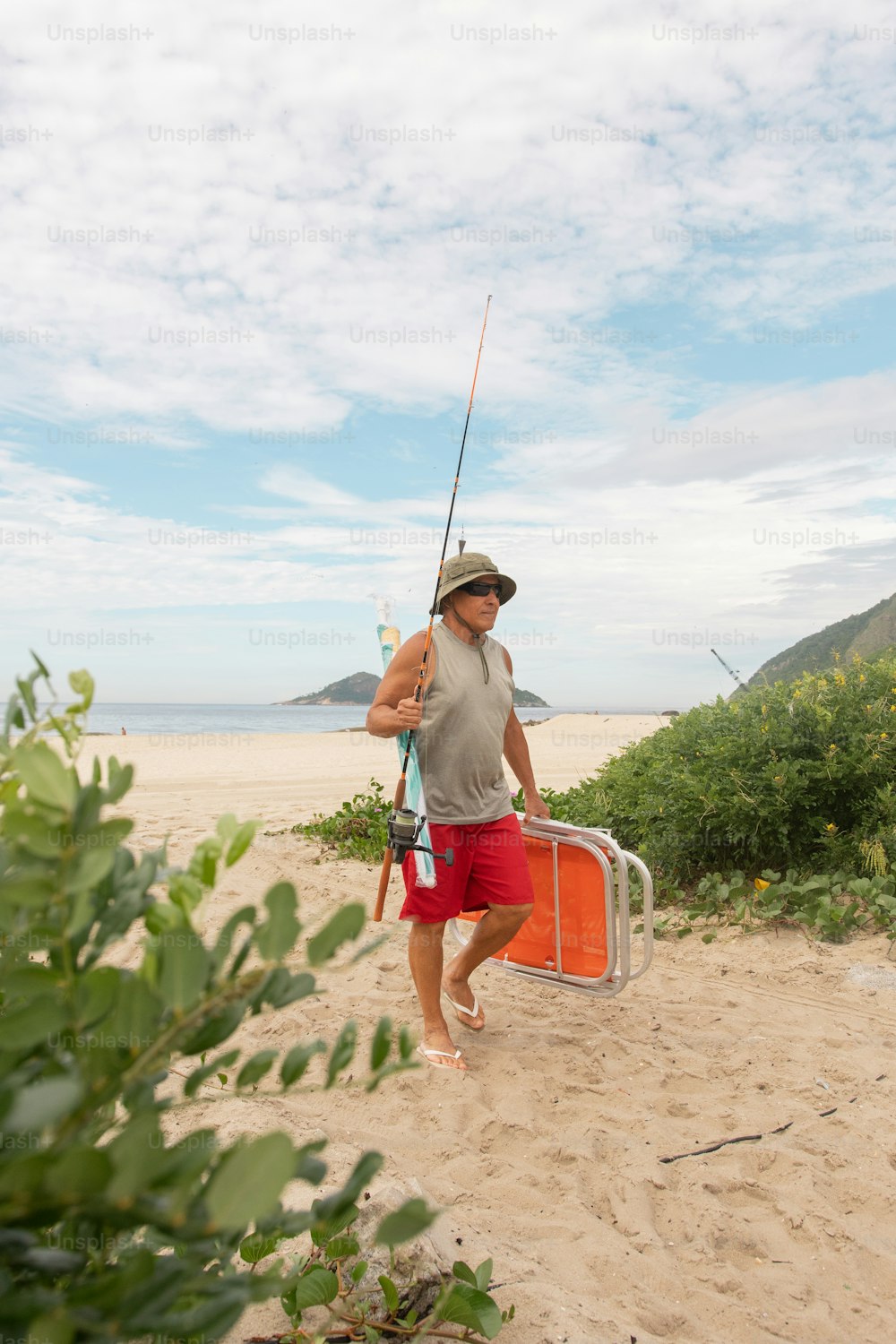 a man walking on a beach carrying a suitcase