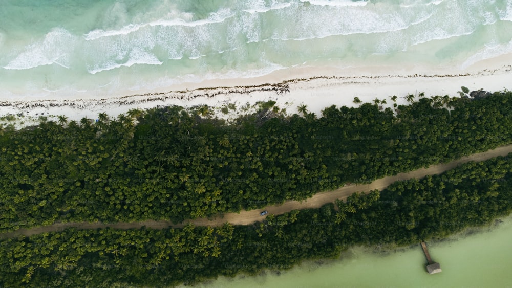 an aerial view of a beach with a boat in the water