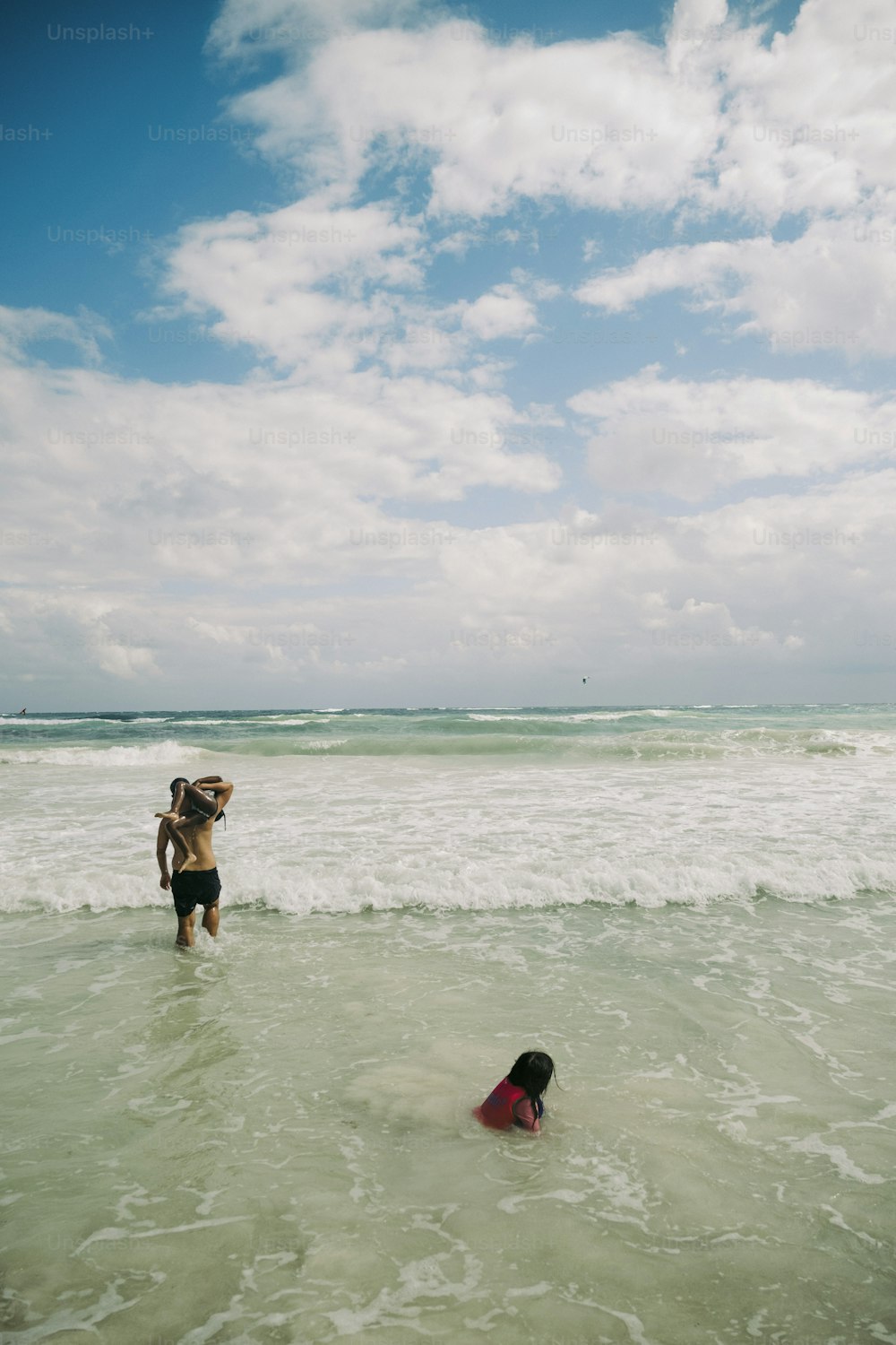 two people in the ocean with a dog