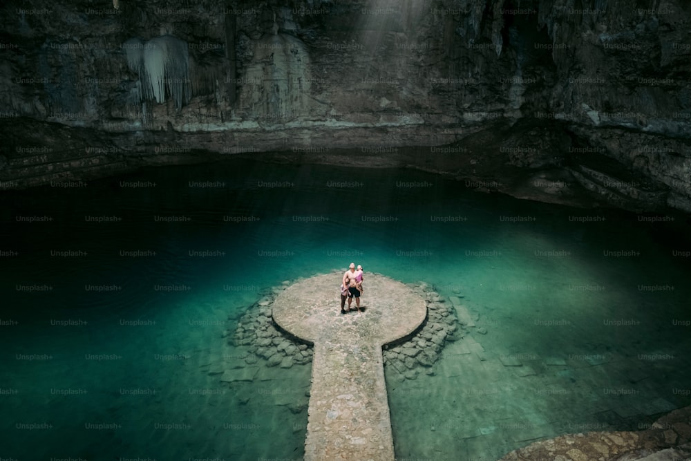 two people standing on a dock in a cave