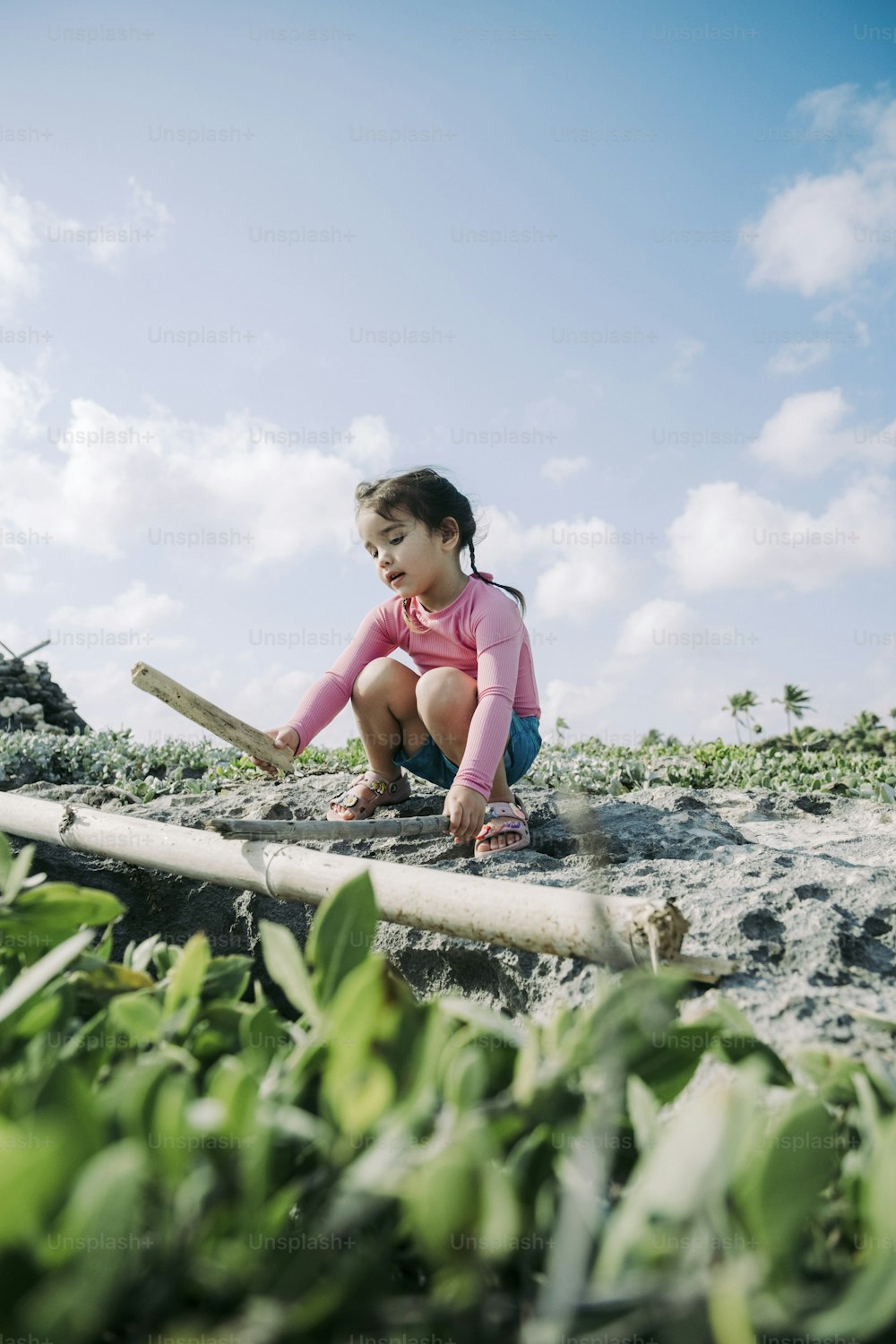 a little girl sitting on top of a wooden log