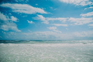 une personne marchant sur la plage avec une planche de surf