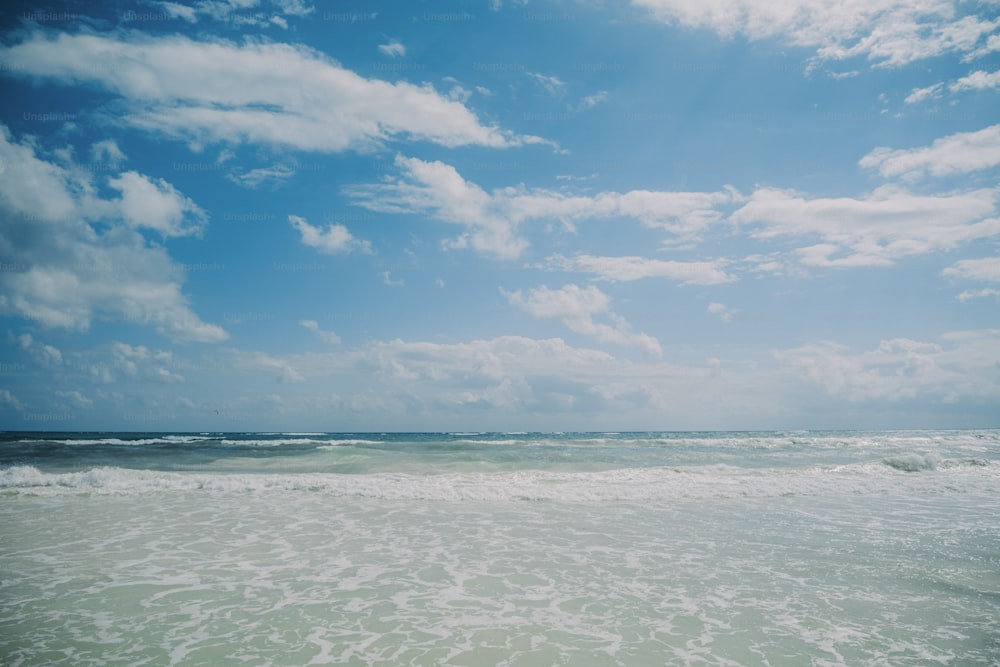 Eine Person, die mit einem Surfbrett am Strand spazieren geht