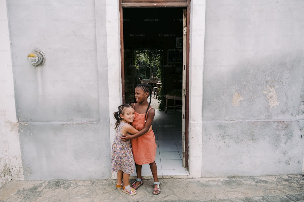 a woman holding a little girl in front of a door