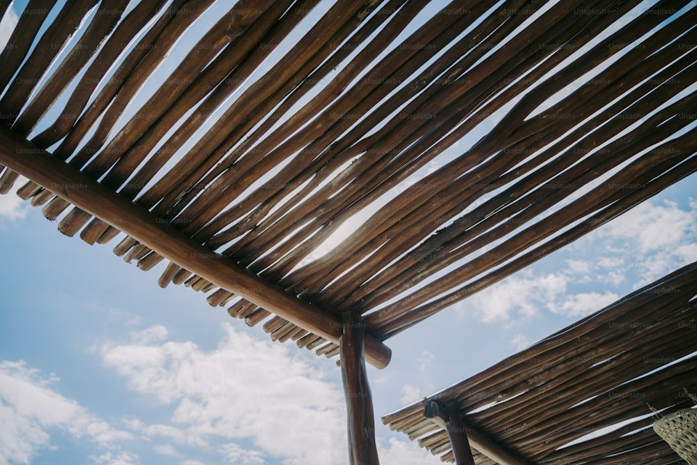 Un primer plano de una estructura de madera bajo un cielo azul nublado