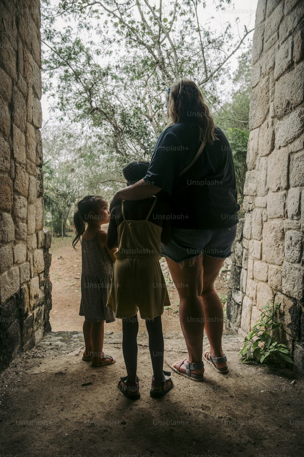 a woman and two little girls standing in a doorway