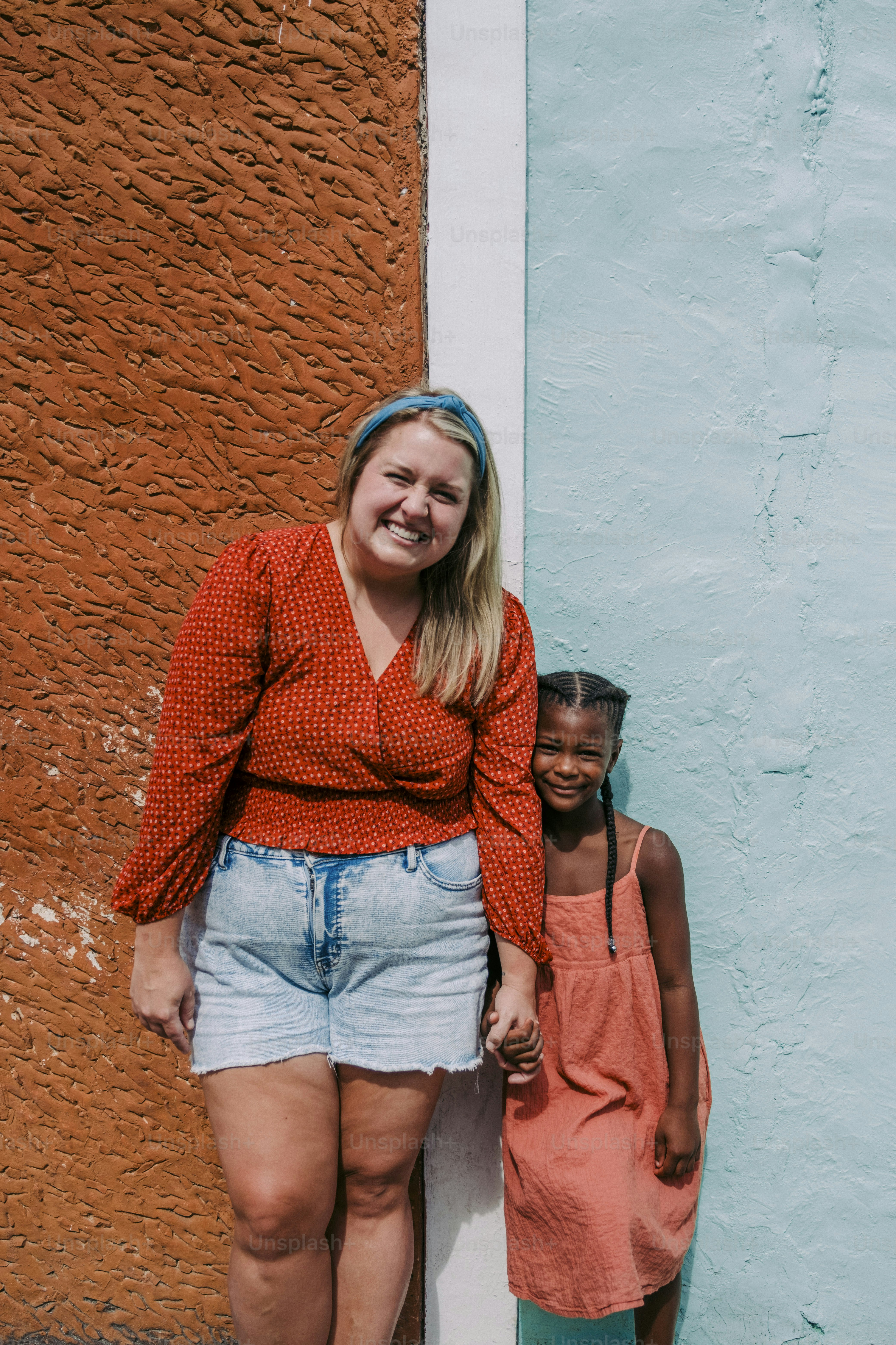 a woman standing next to a little girl
