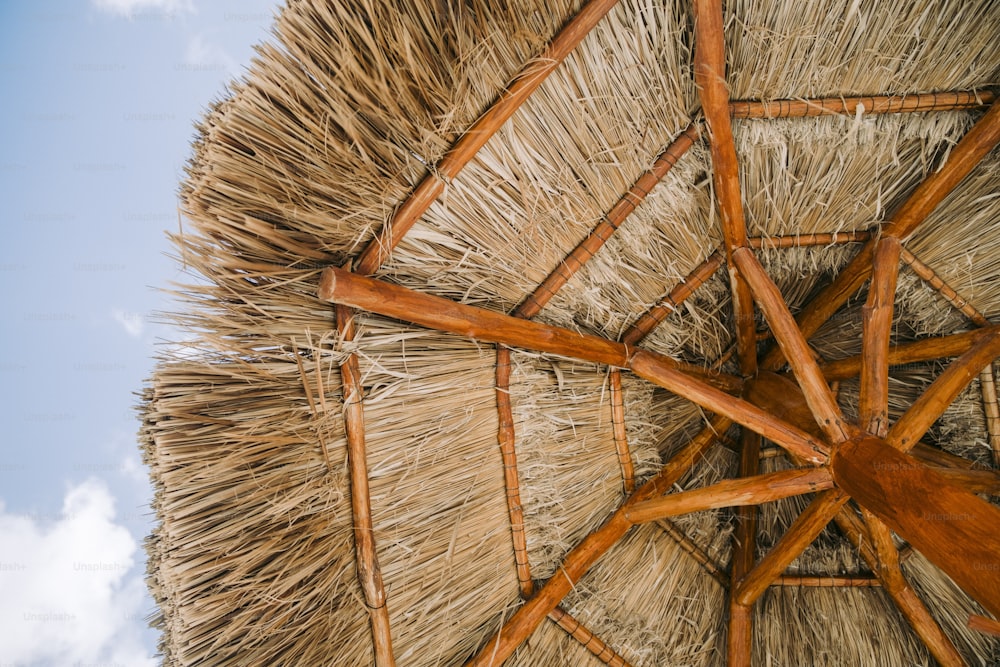 a straw umbrella with a blue sky in the background