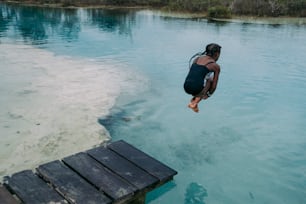 une personne qui saute dans un plan d’eau