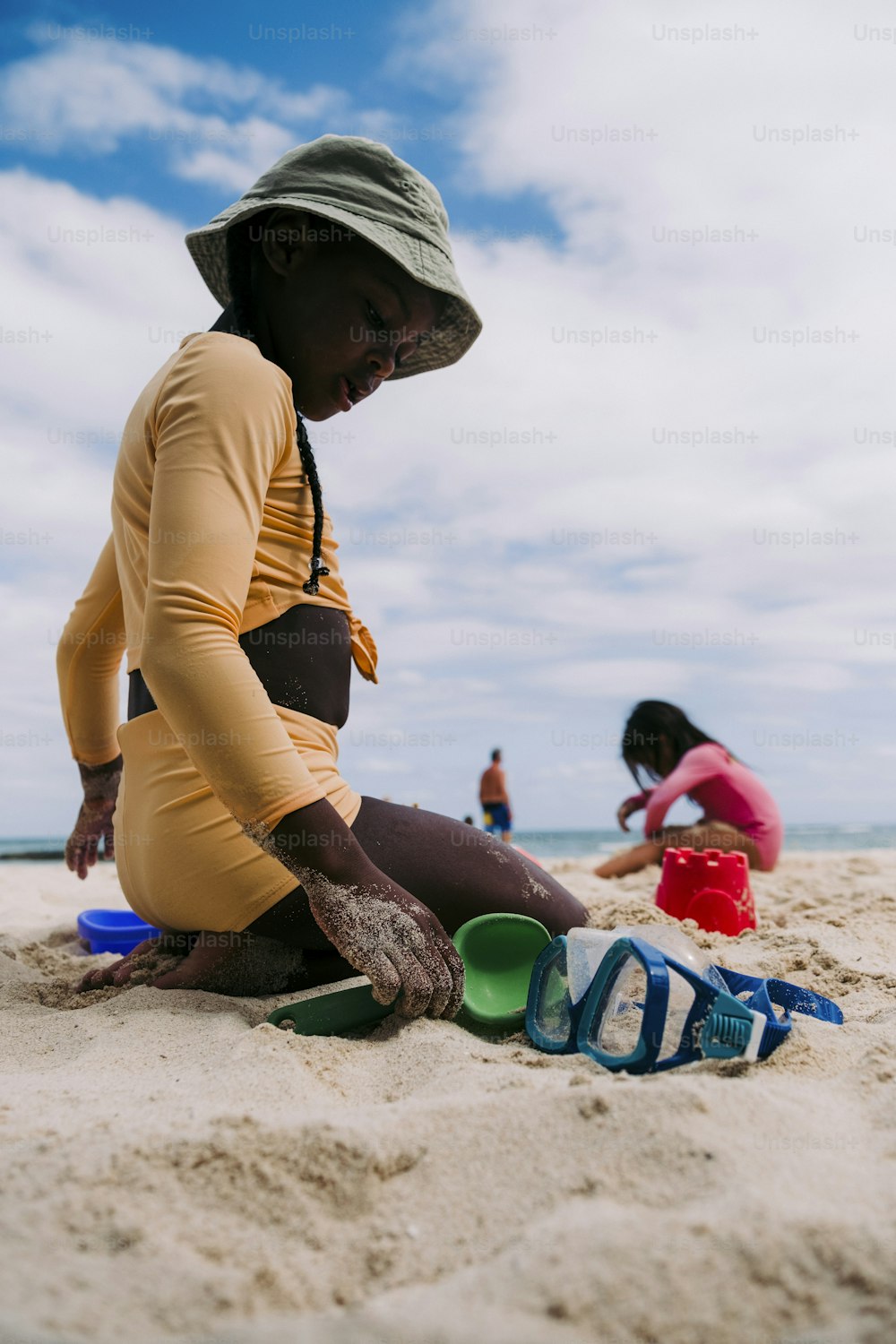 a woman sitting in the sand on the beach