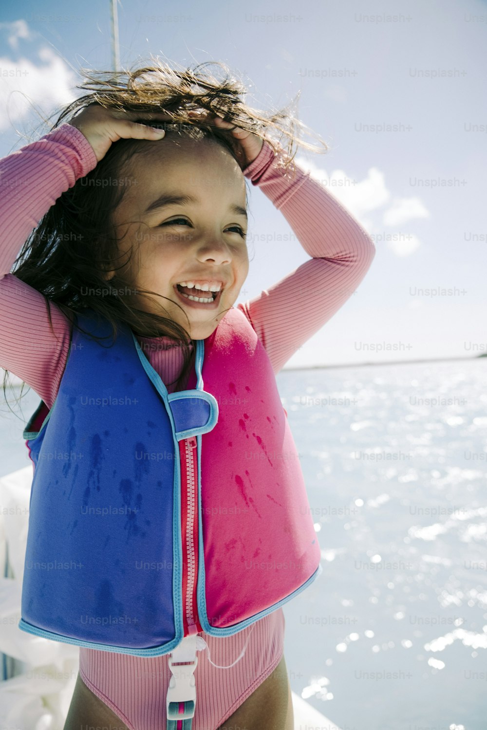 a little girl wearing a life jacket on a boat