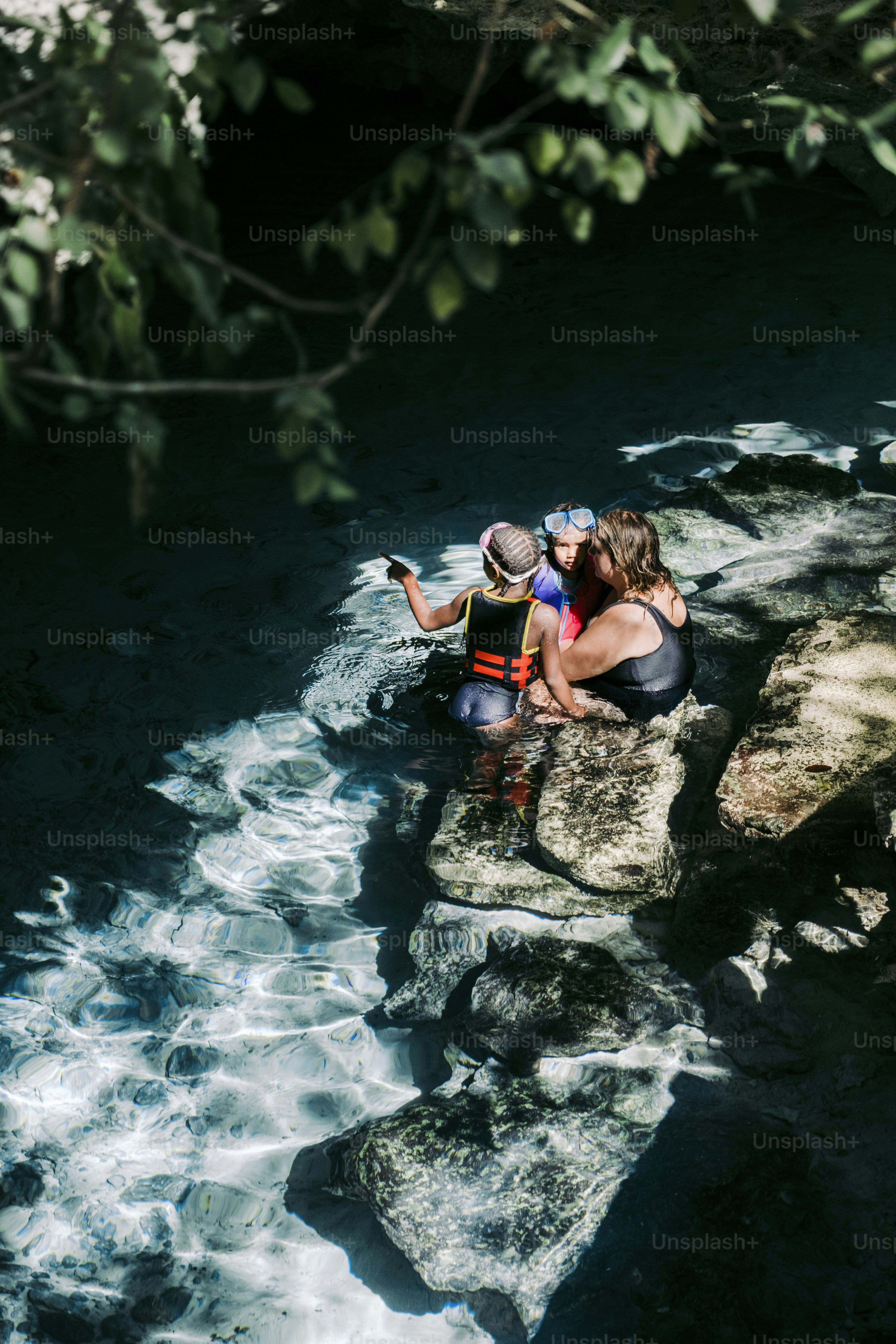 un par de personas que están sentadas en unas rocas
