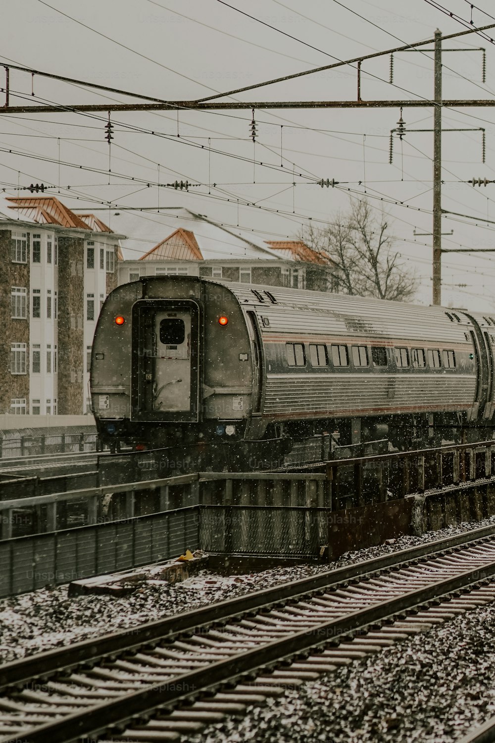 a train traveling down train tracks next to tall buildings