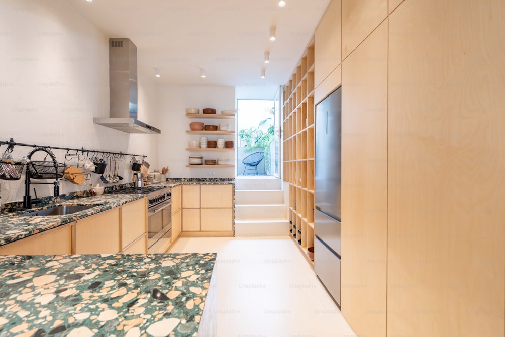 a kitchen with wooden cabinets and marble counter tops