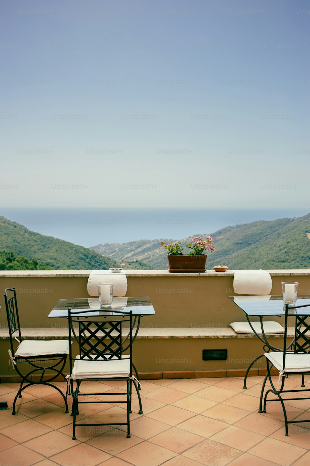 uma mesa e cadeiras em uma varanda com vista para o oceano