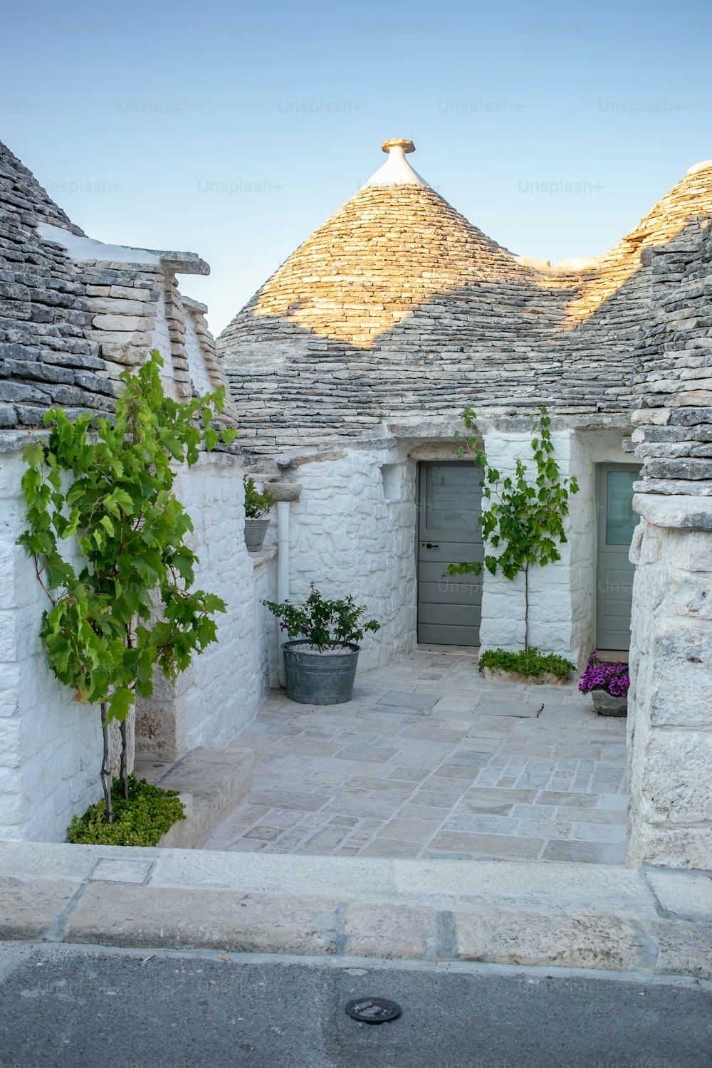 a stone building with a potted tree in front of it