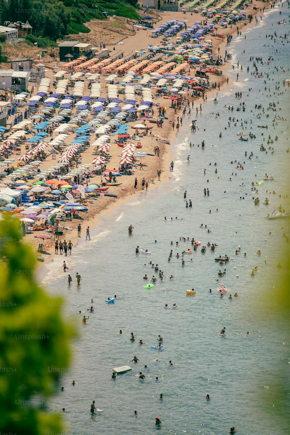 많은 사람들과 우산으로 가득한 붐비는 해변