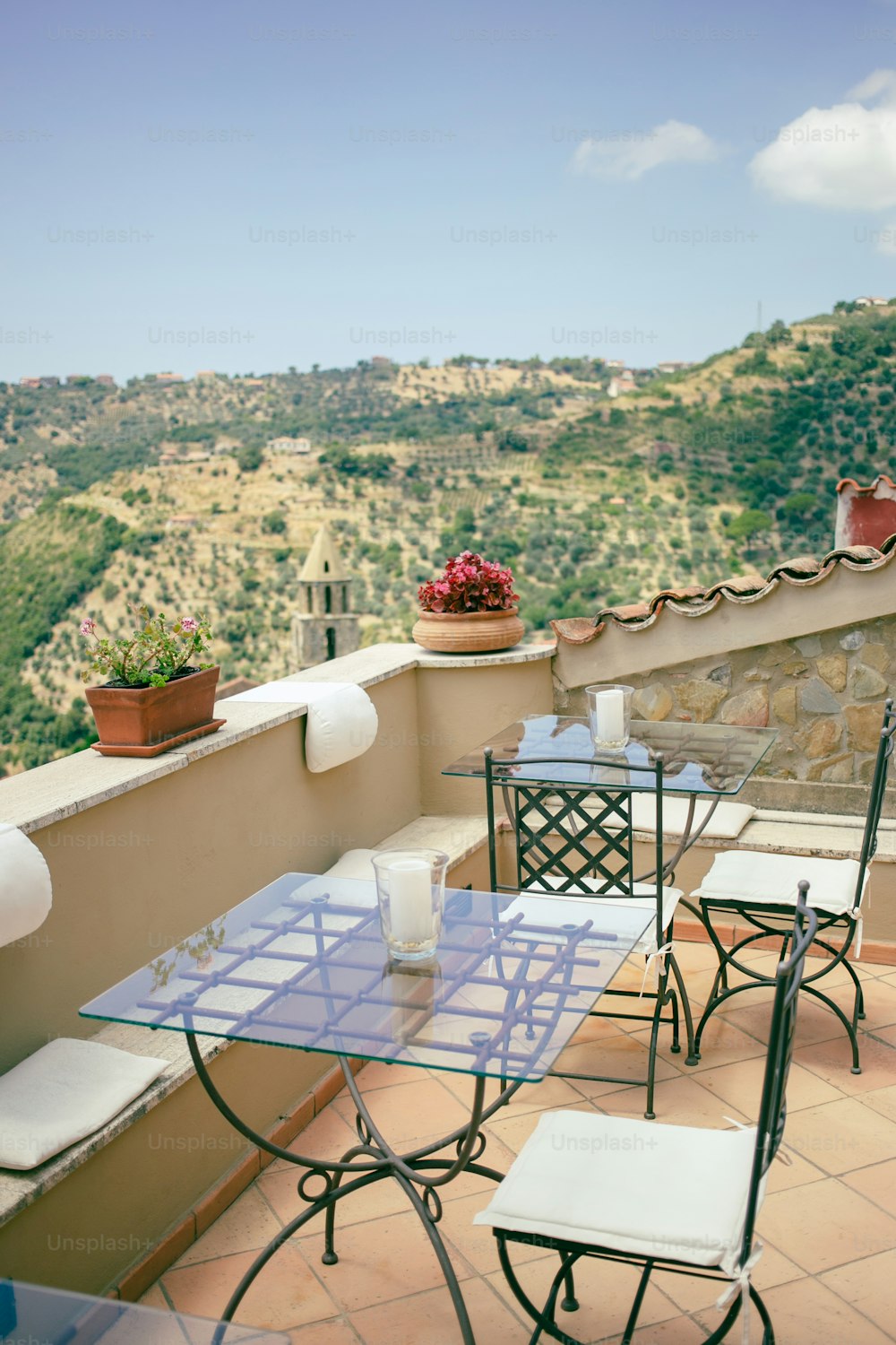 uma mesa e cadeiras em uma varanda com vista para um vale