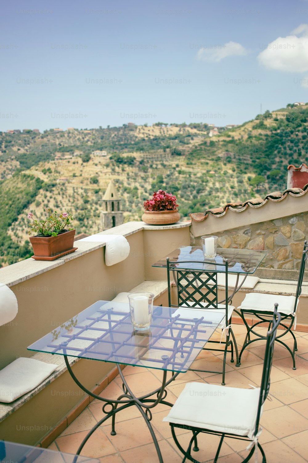 a table and chairs on a balcony overlooking a valley