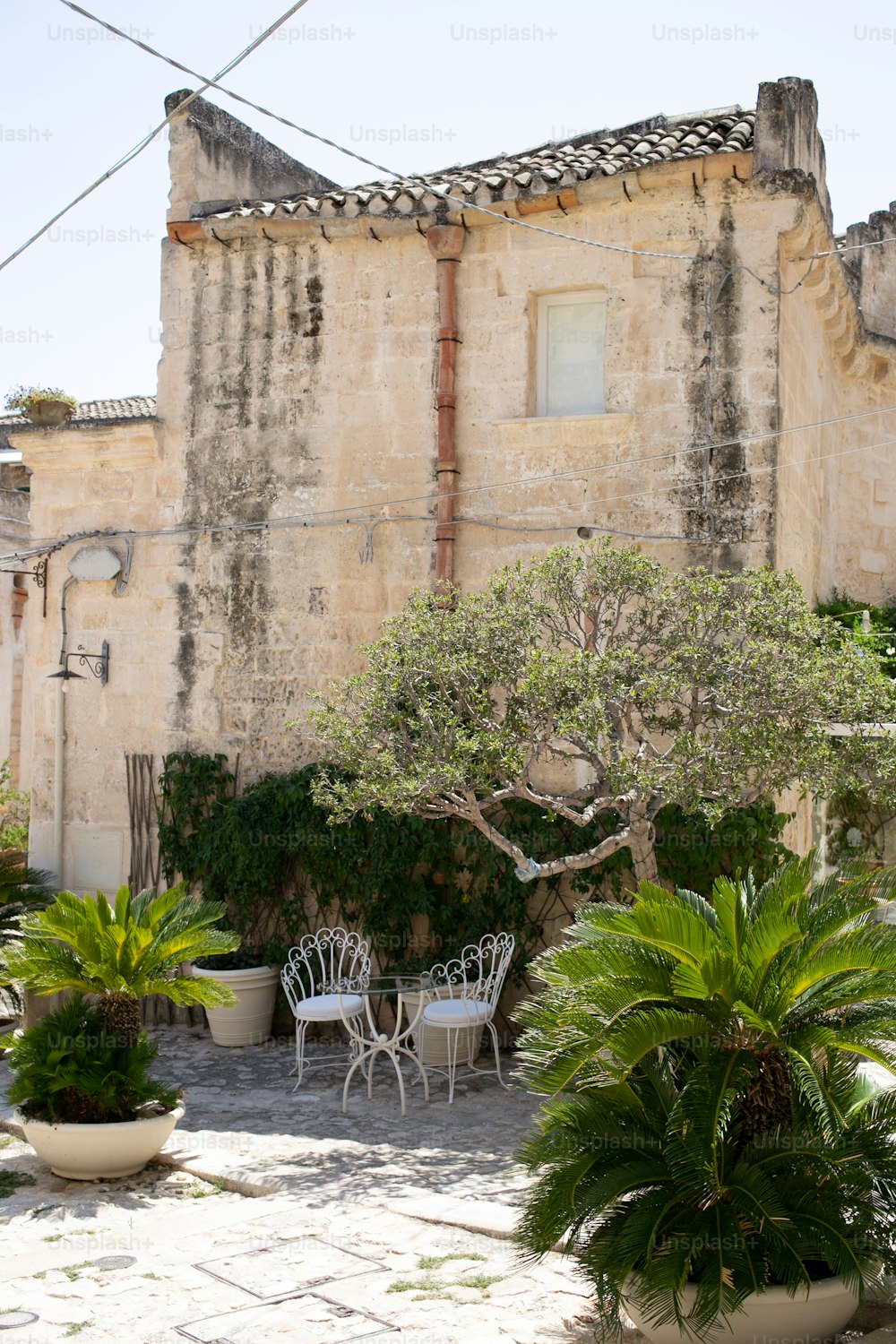 a patio with a table and chairs next to a tree