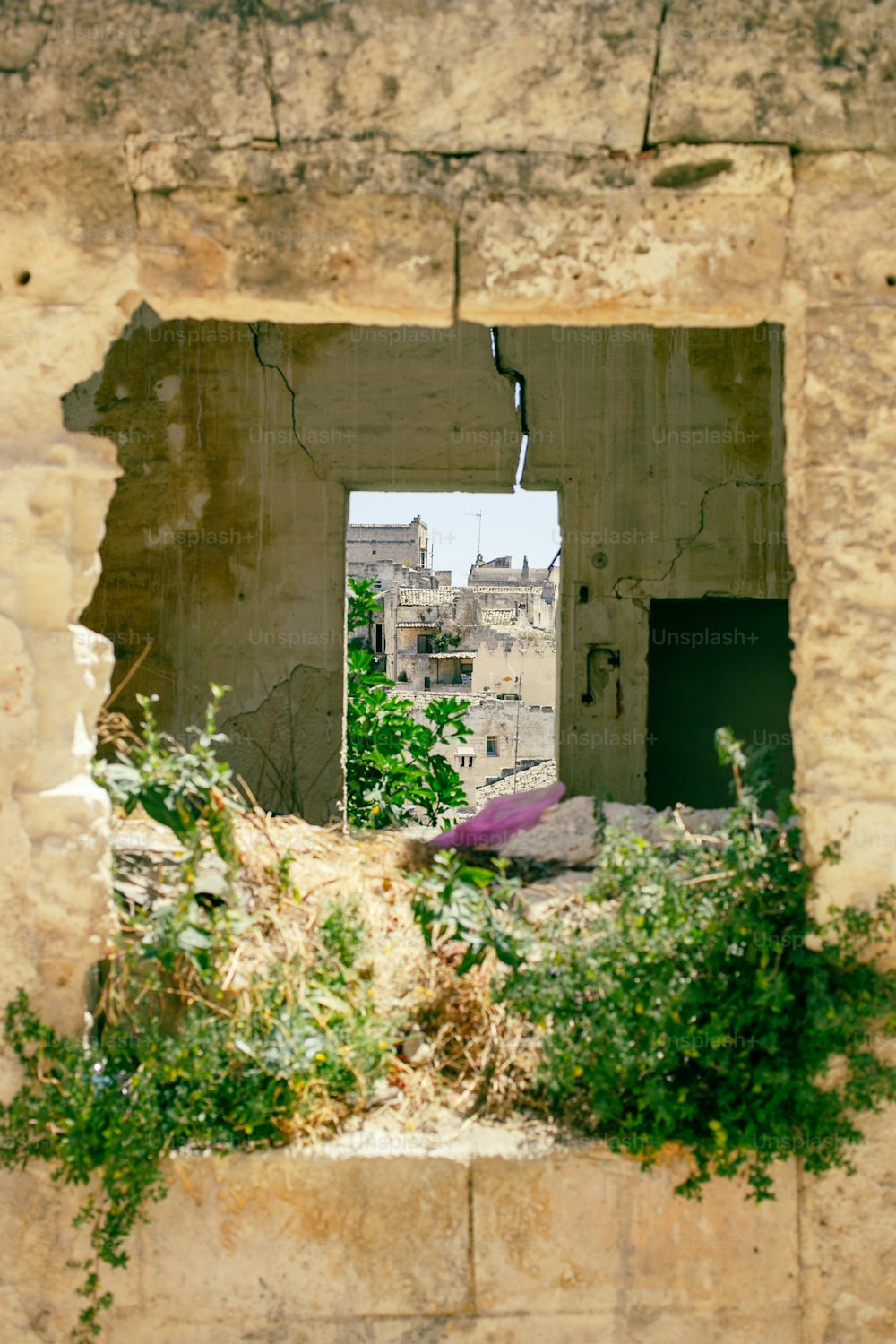 a window in a wall with a view of a city