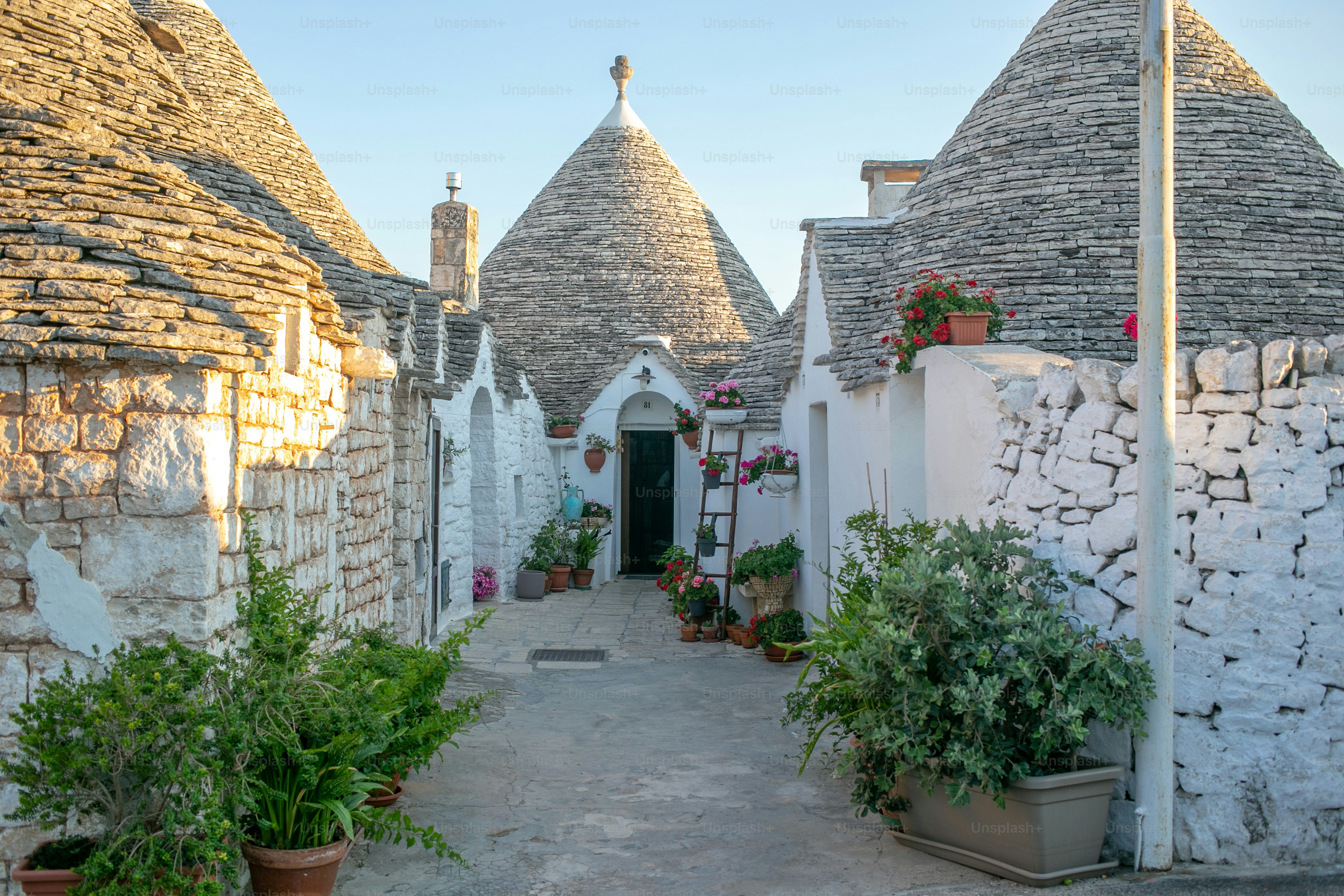 a stone building with potted plants in front of it