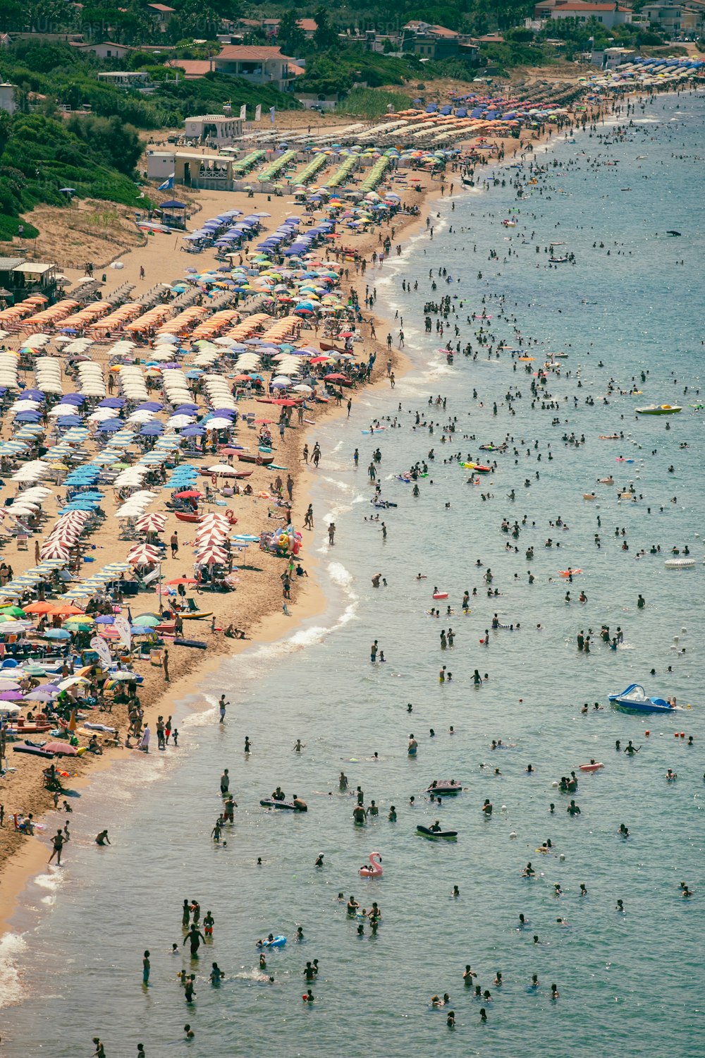 많은 사람들과 우산으로 가득한 붐비는 해변