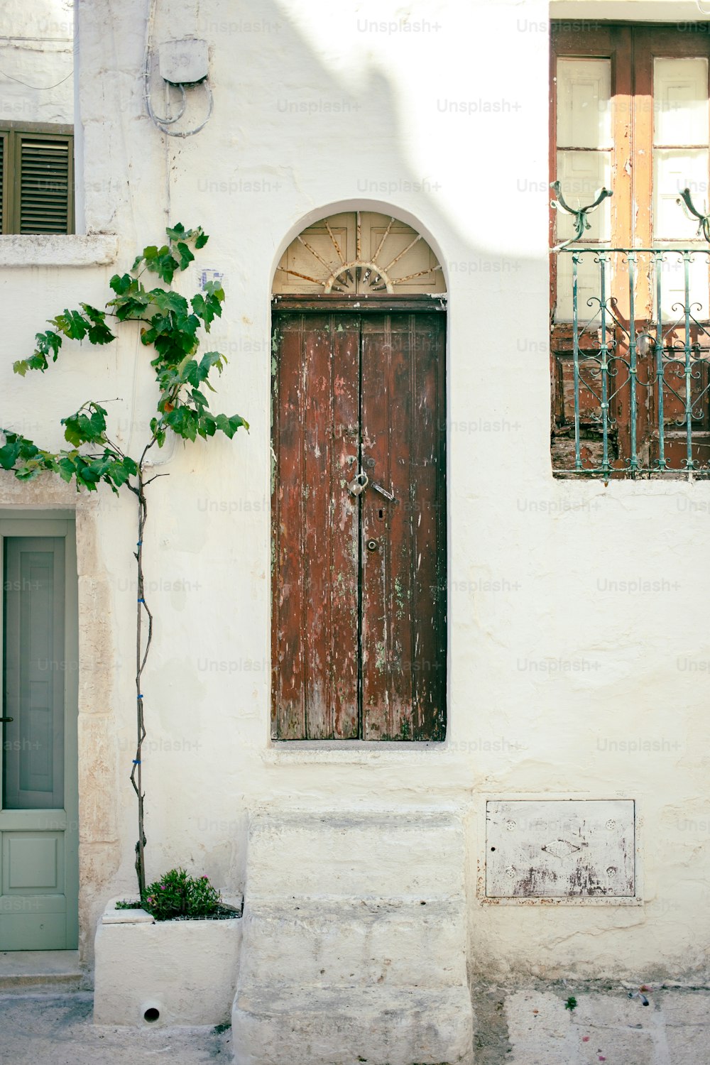 um edifício branco com uma porta e janela de madeira