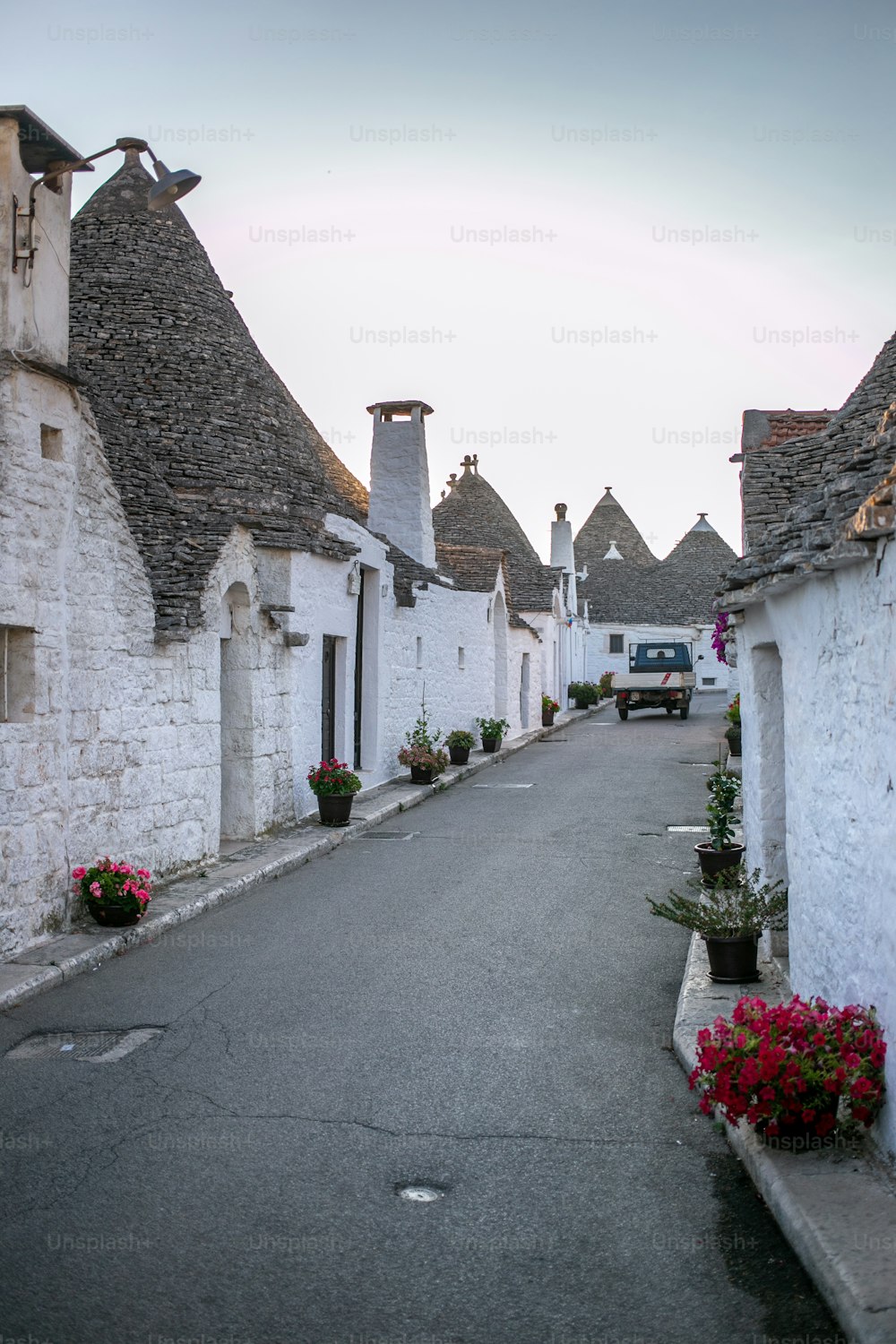 a street lined with white buildings and potted plants