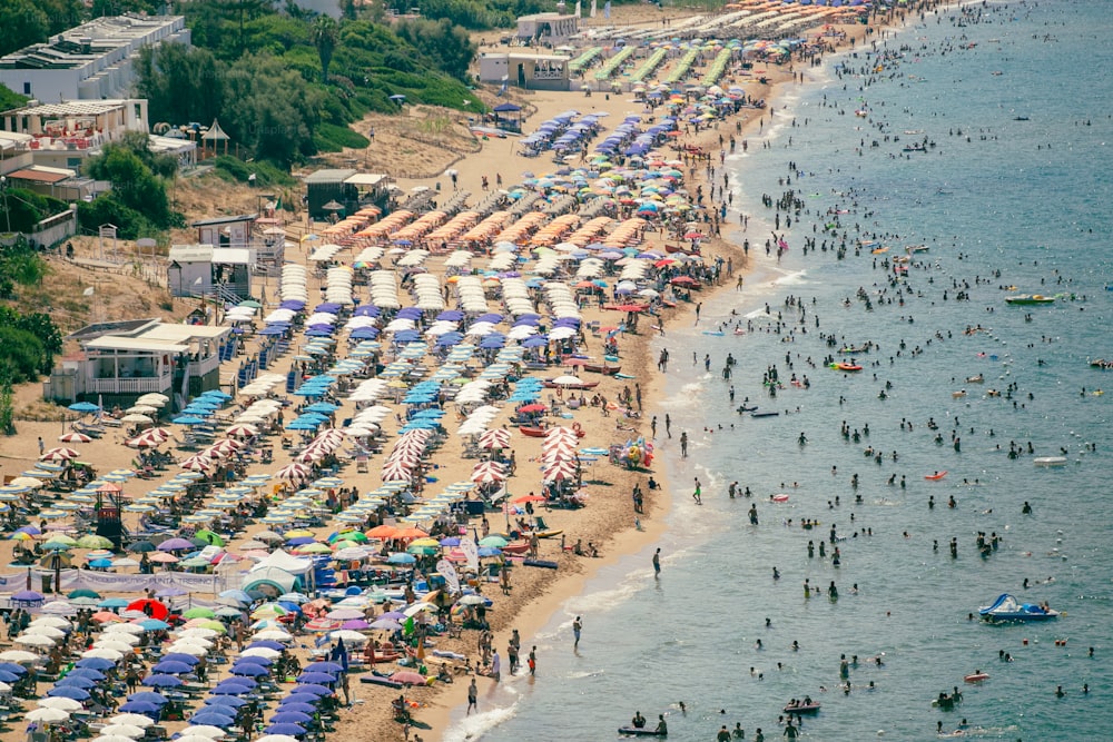 Una playa llena de mucha gente y sombrillas