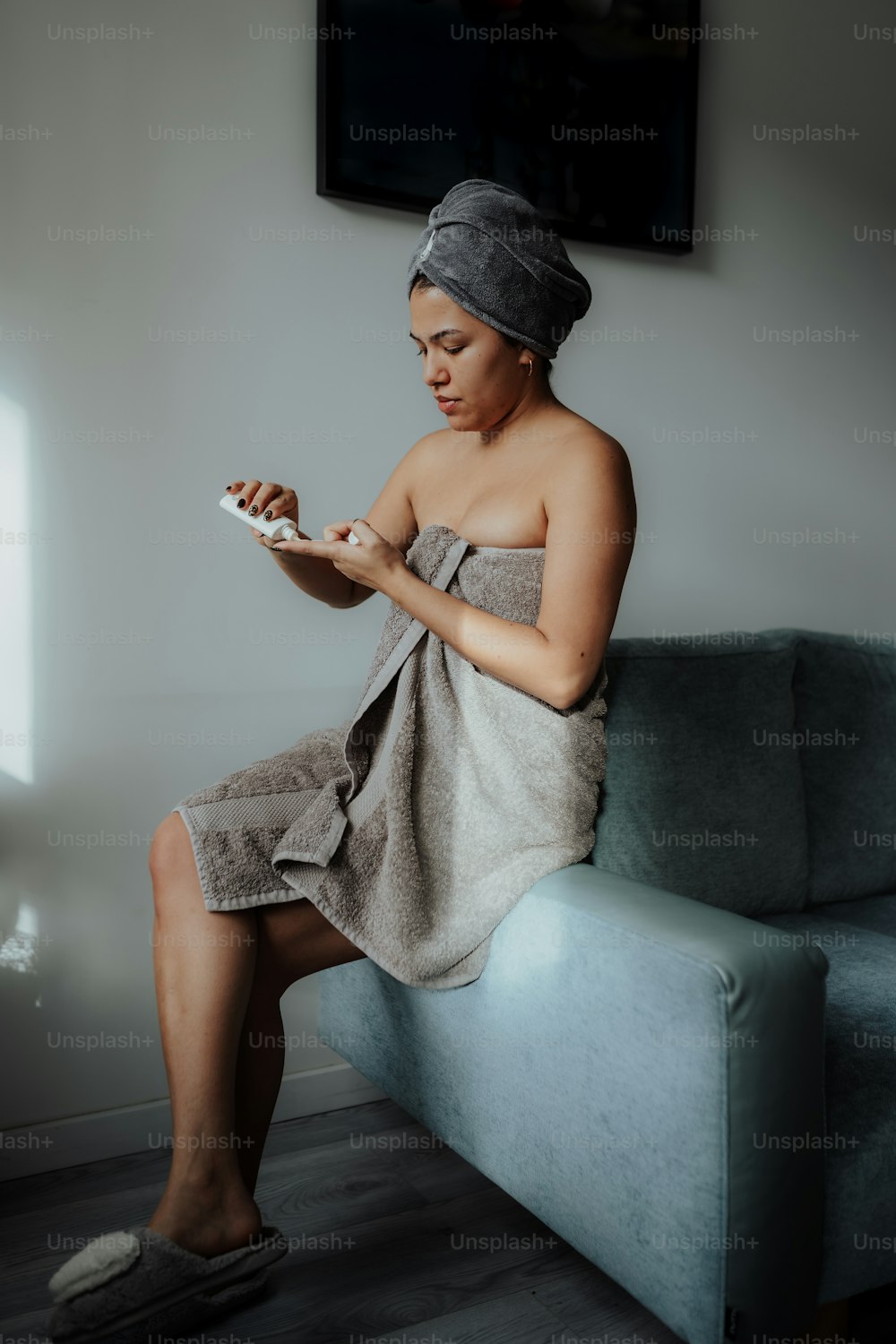 a woman in a towel sitting on a couch